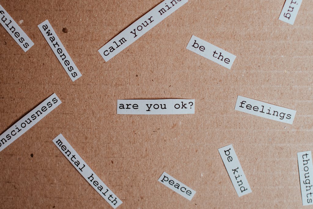 Pappedeckel: Cut-out words promoting mental health awareness on cardboard background.