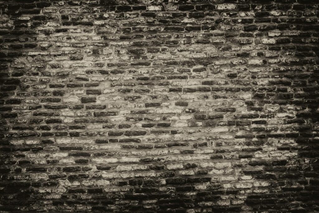 Edivawer Grayscale textured brick wall background with rough surface.