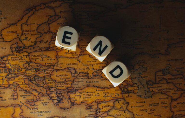 Lufanest Close-up of dice spelling 'END' placed on a map of Europe, symbolizing finish line or travel completion.