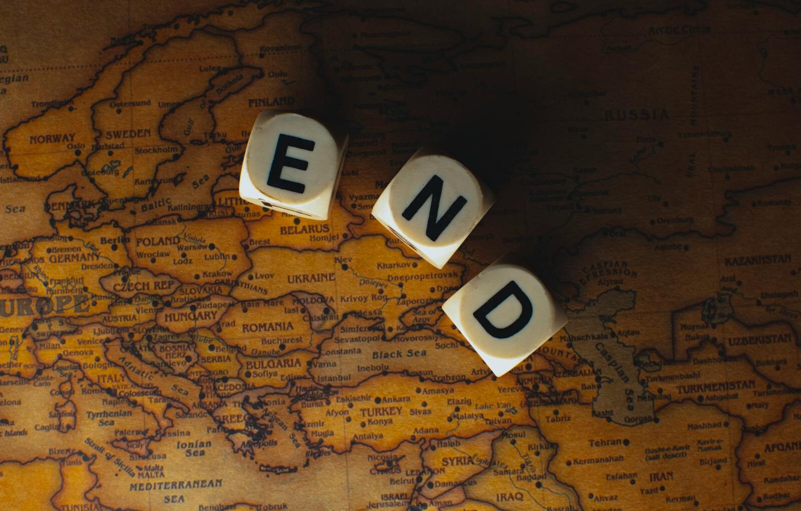 Lufanest Close-up of dice spelling 'END' placed on a map of Europe, symbolizing finish line or travel completion.