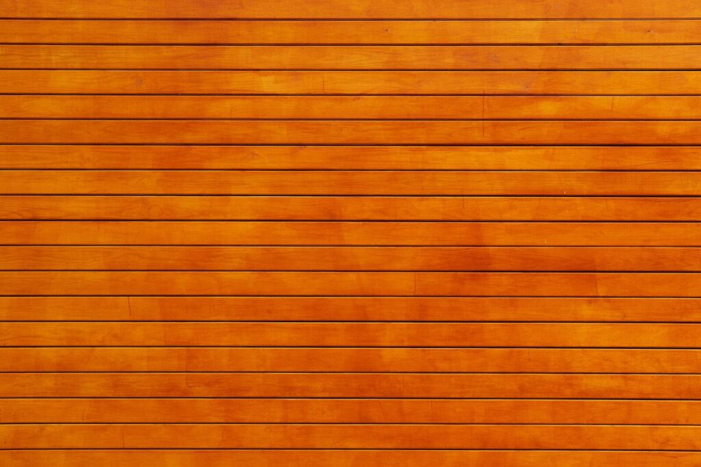 Edivawer Close-up of a vibrant orange wooden wall texture, ideal for backgrounds.