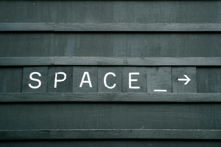Dolfier Close-up of a minimalist wooden sign with 'SPACE' in capital letters and an arrow, creating a conceptual theme.