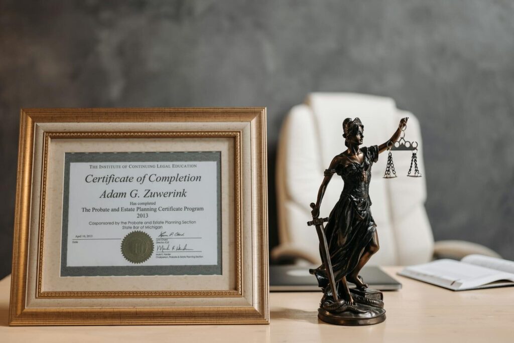 Six Sigma Certification Online A framed legal certificate and Lady Justice figurine on a desk in a law office setting.