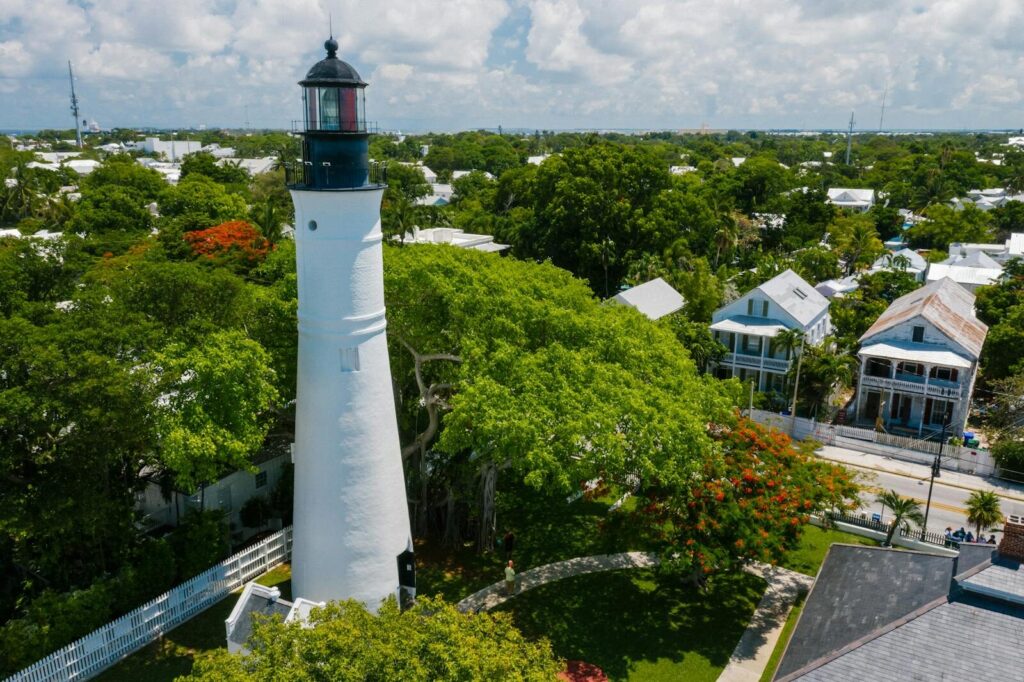Fetid Key OSRS Aerial view of the iconic Key West Lighthouse surrounded by vibrant trees and historic houses.