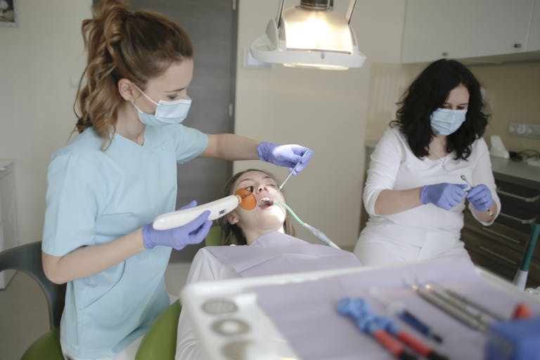 Dental Software News Today A dentist and nurse in a clinic working on a patient's dental care with advanced tools.