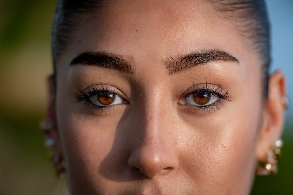 Trios 5 Invisalign Submission A detailed close-up of a woman's face highlighting her striking brown eyes and natural beauty.