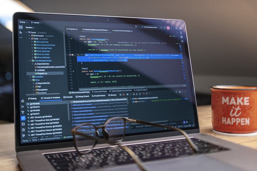 630 Area Code A laptop displaying code editor with a motivational mug that reads 'Make It Happen' on a workspace.