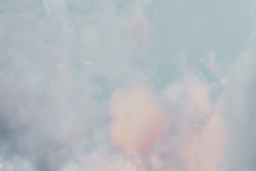 Newtopy A serene scene of pastel clouds and a subtle moon in a calming sky, perfect for a peaceful backdrop.