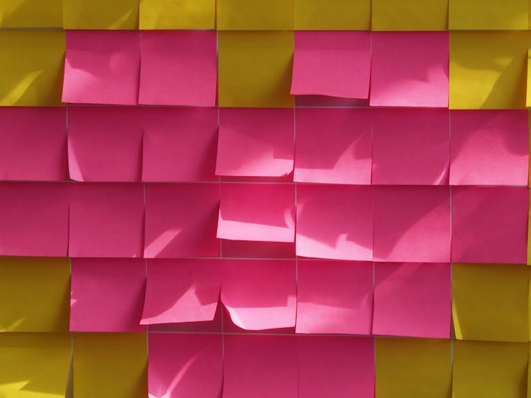 Kongotech Org A vibrant arrangement of colorful sticky notes illuminated by sunlight, creating playful shadows.