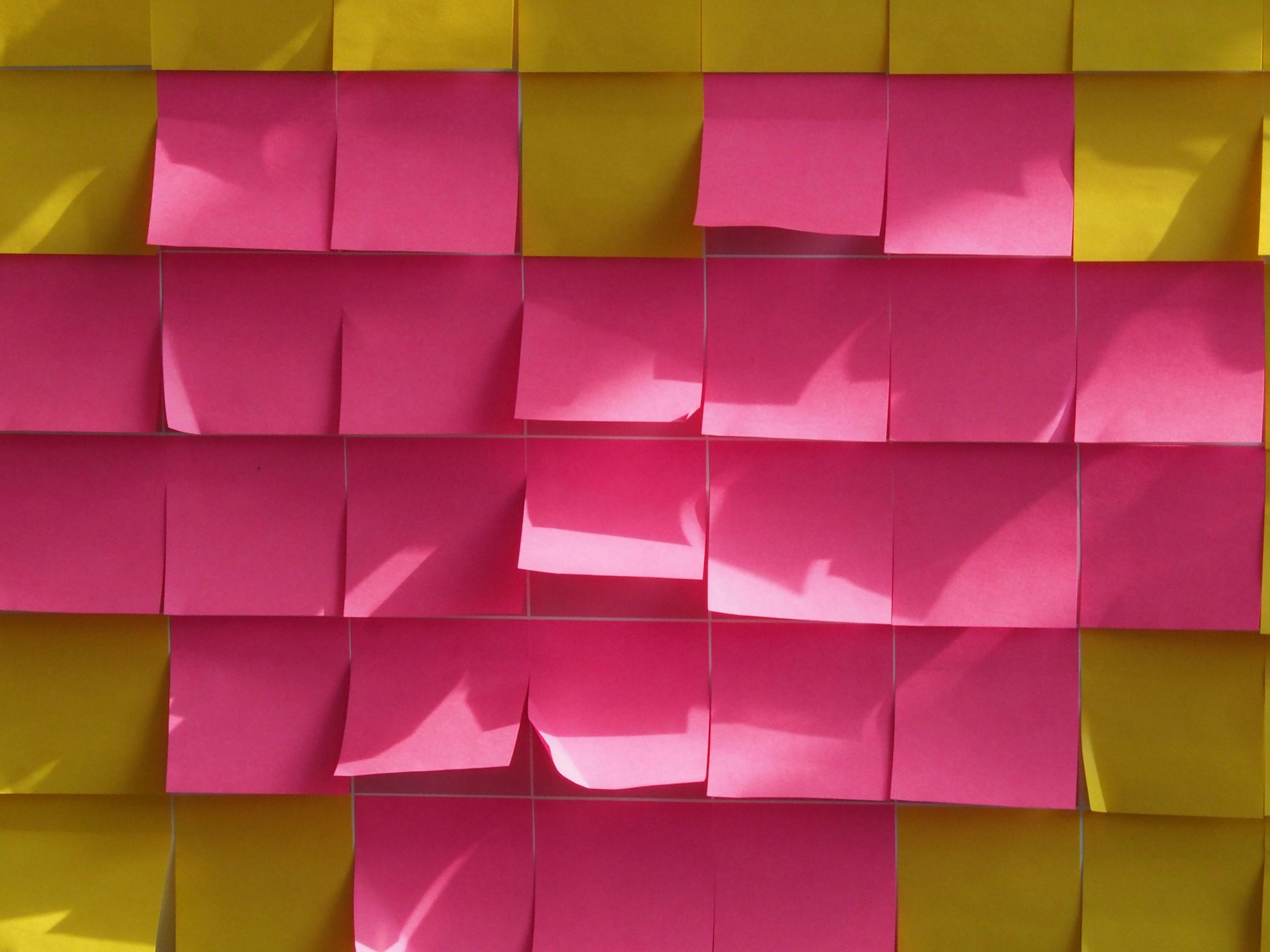 Kongotech Org A vibrant arrangement of colorful sticky notes illuminated by sunlight, creating playful shadows.