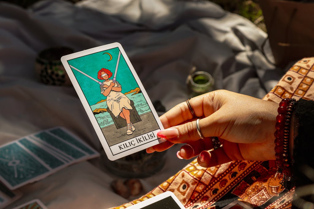 Celtic vs Kairat Prediction A woman's hand holds a tarot card in an outdoor setting, showcasing mystical art and symbolism.
