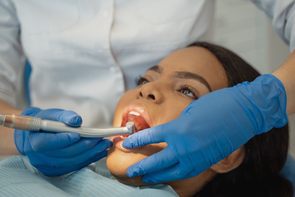 https://uitly.blog/dental-software-news-today/ Close-up of a dentist performing a dental treatment on a patient.