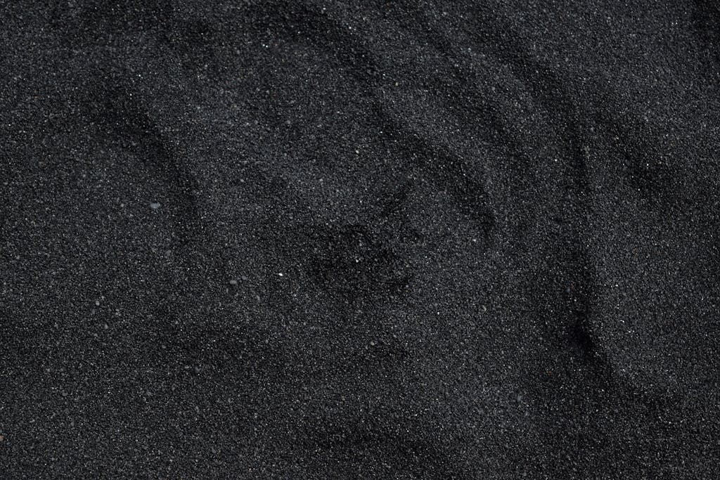 MMSBRE Close-up of black sand texture from Waimea Beach in Hawaii. Ideal for backgrounds.