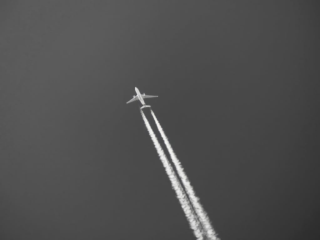United Flight UA109 Diversion Monochrome image of a jet with contrails soaring high above Miami sky.