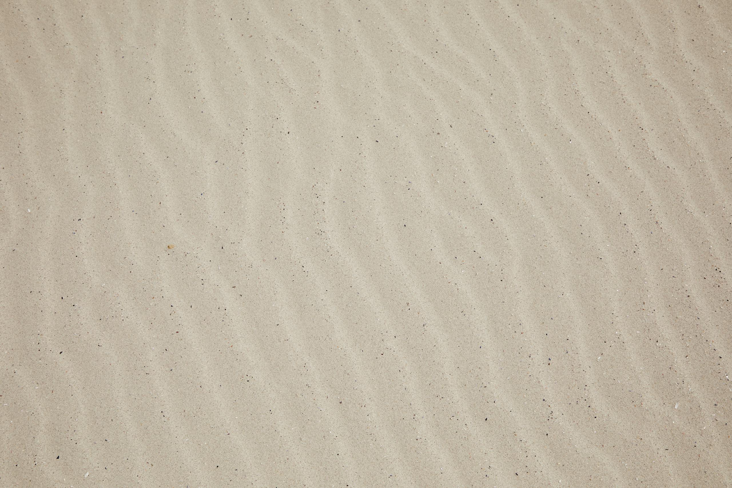 SocialMediaGirl Top view of empty dry plain surface of beach covered with sand in daytime