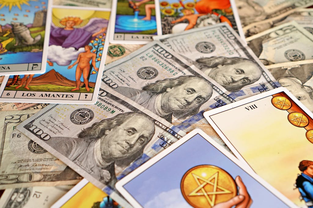 Redeepseek Vibrant tarot cards and US dollar bills create a mystic and affluent flat lay composition.